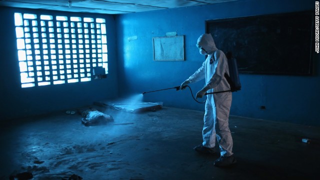 A worker disinfects a deceased Ebola patient.